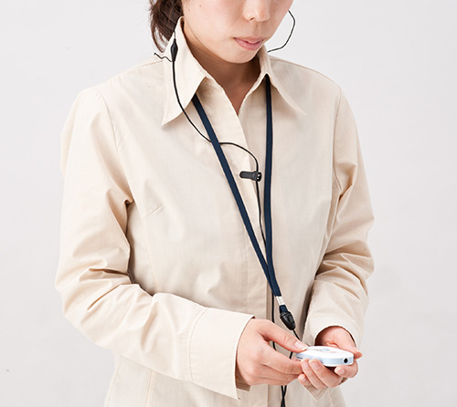 ポケット型補聴器を装着する女性の写真